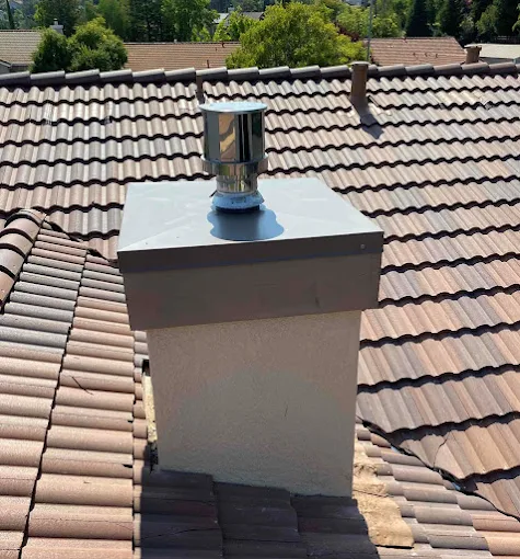 Chimney with cap on tiled roof
